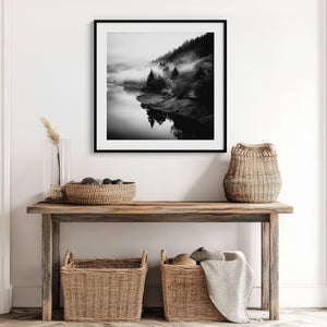 Black-framed Mistwater Valley river print above a rustic console with woven baskets.