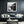 Black-framed Mistwater Valley print above a dark blue sofa with pale cushions.