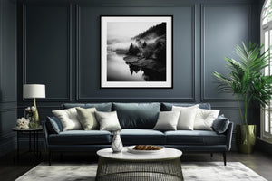Black-framed Mistwater Valley print above a dark blue sofa with pale cushions.