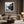 Black-framed misty river print above a curved beige sofa and round coffee table.
