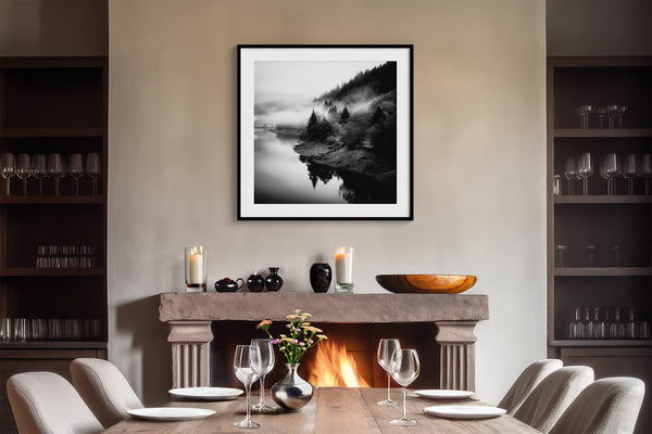 Black-framed river artwork above a fireplace set for dining, with lit candles.