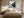 Black-framed misty river artwork above a cream bed between matching bedside lamps.
