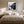 Black-framed misty river artwork above a cream bed between matching bedside lamps.