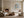 Framed blue and beige abstract artwork displayed above a low ledge near a lit fireplace.