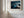 Close view of matted desert dune artwork in a light wood frame on a white paneled wall.