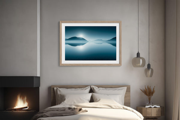 Light wood-framed mountain lake print above a bed beside a lit fireplace.