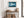 Blue Mirror print in a light wood frame above a rustic console table with woven baskets.