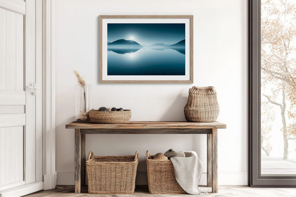 Blue Mirror print in a light wood frame above a rustic console table with woven baskets.