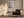 Light wood-framed cherry blossom print above a dark armchair, side table, and floor lamp.