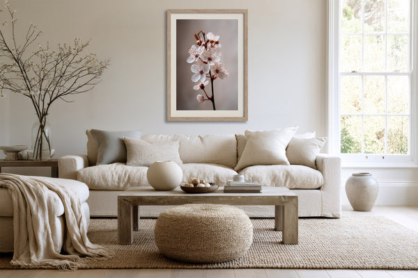 Light wood-framed cherry blossom print above a cream sofa and wooden coffee table.