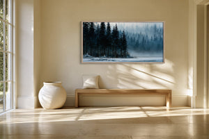 Framed winter forest lake artwork above a wooden bench beside a large ceramic vase.