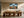 Framed mountain ridge artwork above a long wooden dining table with sculptural chairs.