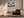 Framed mountain ridge artwork above a dark armchair, side table, and floor lamp.