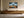 Framed mountain ridge artwork hung above a long wooden sideboard with ceramic vases.