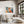 White-framed geometric fox print above a cream sofa beside a large dark-trimmed window.
