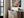 Thin dark-framed geometric fox print above a slatted console table with stacked books and a potted plant.