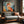 Wood-framed geometric fox print above a gray upholstered wood sofa beside a sunlit window.