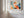 Light wood-framed geometric fox print displayed on a white paneled wall near tall windows.