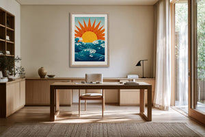 Framed golden sun and teal wave illustration displayed above a wooden desk.