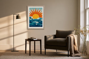 Framed sun and ocean illustration beside a dark armchair and floor lamp.