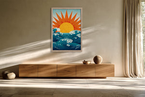 Framed golden sun over teal waves illustration above a low wooden sideboard.