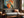 Framed abstract hare artwork above a gray wooden sofa beside a sunlit window.