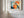 Close view of a wood-framed abstract hare print on a white paneled wall.