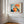 Close view of a wood-framed abstract hare print on a white paneled wall.