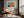 Light-framed abstract hare print above a tan leather lounge chair by a window.