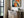 Thin dark-framed abstract hare print above a slatted console with books and a potted plant.