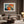 Light-framed abstract hare artwork above a cream sectional with a round wood coffee table.