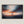 Canvas wall art of a sailboat at sunset with stormy skies. A dramatic ocean print balancing calm and intensity. Ready to hang.