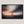 Canvas wall art of a sailboat at sunset with stormy skies. A dramatic ocean print balancing calm and intensity. Ready to hang.