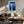 White-framed blue forest artwork above a cream sofa and wooden coffee table.