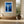 White-framed forest print above a built-in bench beside a large ceramic urn.