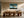 Leaning Light tree artwork in a light wood frame above a long dining table.