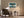 Framed Leaning Light tree artwork above an upholstered armchair and side table with floor lamp.
