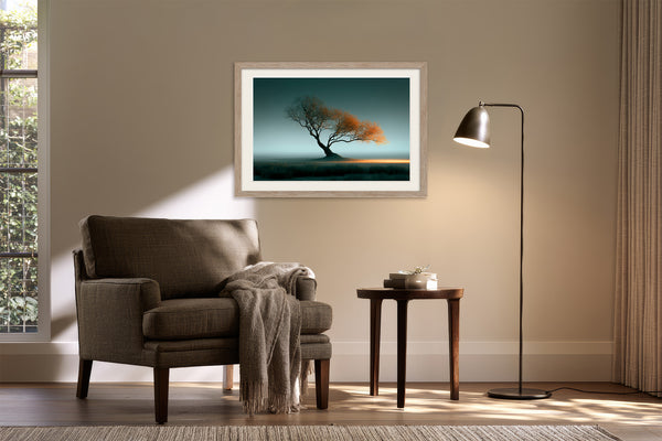 Framed Leaning Light tree artwork above an upholstered armchair and side table with floor lamp.