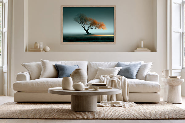 Framed Leaning Light tree artwork displayed above a white sofa with blue and cream cushions.