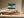 Framed Leaning Light tree artwork above a low wooden sideboard with ceramic objects.