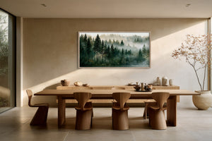 Framed misty forest artwork above a long wooden dining table with sculptural chairs.