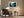 Light wood-framed misty forest artwork above an armchair beside a floor lamp and side table.