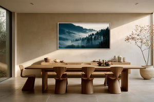 Framed conifer forest landscape displayed above a long wooden dining table.