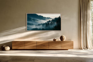Framed misty forest artwork above a long wooden sideboard and floor-length curtains.