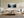 Framed misty forest lake artwork above a low sofa and wooden coffee table.