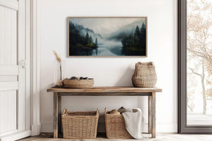 Framed misty forest lake artwork above a rustic console with woven baskets.