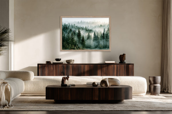 Light wood-framed evergreen forest artwork above a dark wood sideboard behind a curved white sofa.