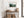 Light wood-framed misty forest artwork above a rustic console table with woven baskets.