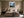 Framed misty mountain forest artwork centered above a beige bed with dark wood nightstands.