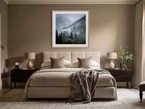 Framed misty mountain forest artwork centered above a beige bed with dark wood nightstands.